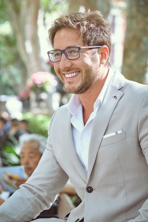Laughing man in eyeglasses looking away outdoors