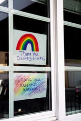 Angled shot of two handmade signs taped on house window thanking essential workers during lockdown