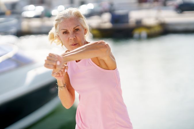 Older woman practicing punches in a coastal pier