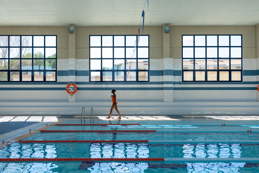 Black young woman walking by the curb at the swimming pool