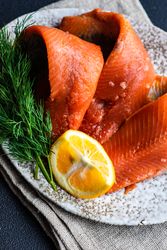 Raw herring fillets on plate served with dill and lemon