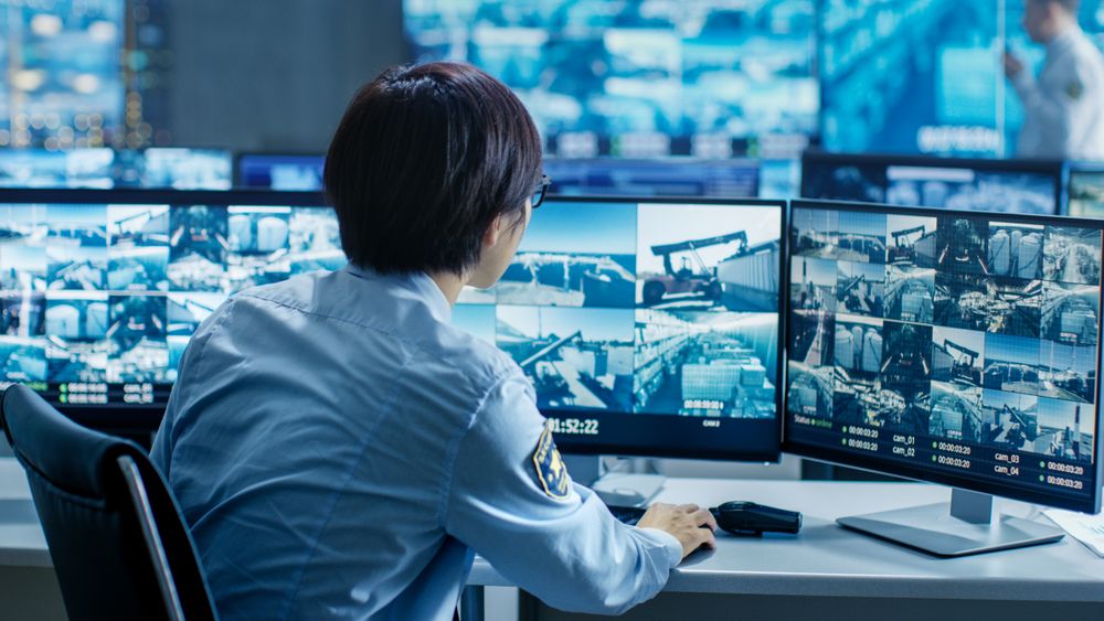 In the Security Control Room Officer Monitors Multiple Screens for Suspicious Activities