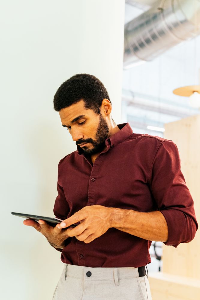 Handsome Latino man working with a tablet in a coworking