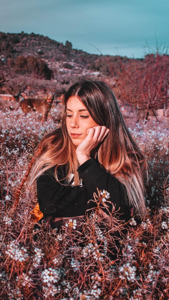 Woman in sweater laying on dried leaves