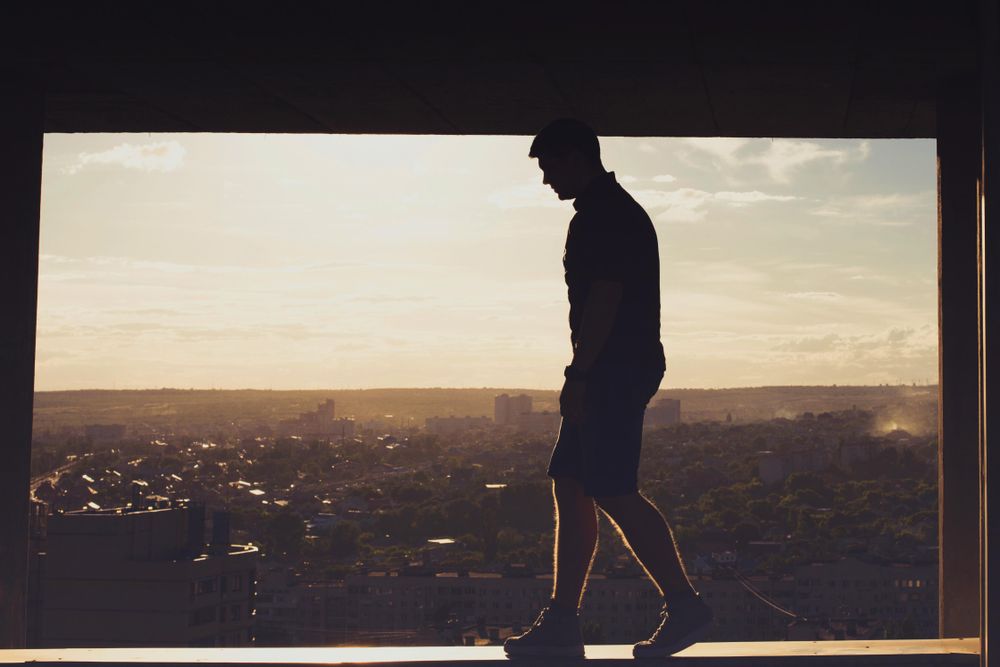 Silhouette of man balancing on top of building