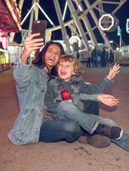 Happy mother and son taking selfie in amusement park