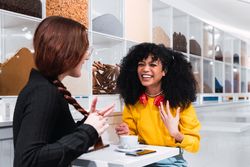 Happy young women drinking coffee and talking in cafe