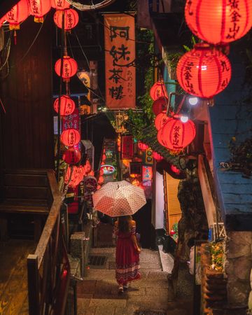Back view of woman holding an umbrella standing under Chinese New Year decoration