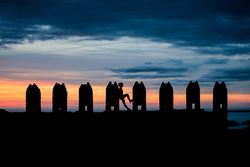 Silhouette of person between stone sculptures in sunset