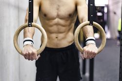 Man training with gymnastic rings in gym