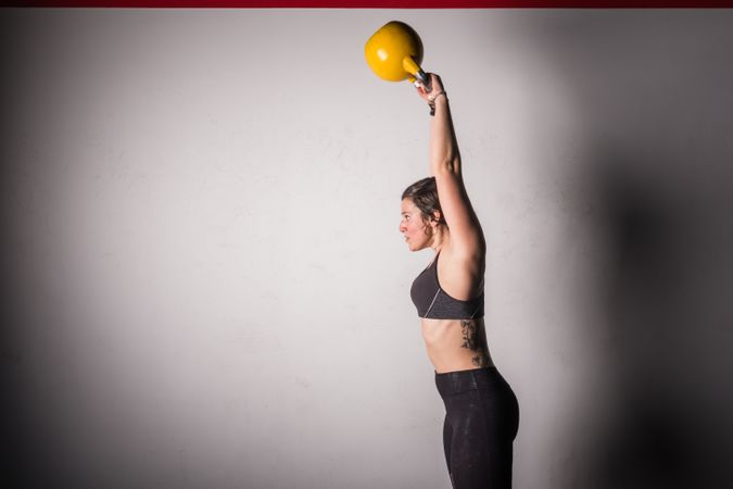 woman lifting kettlebell in gym