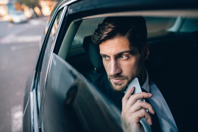 Business executive thinking and looking outside window of taxi