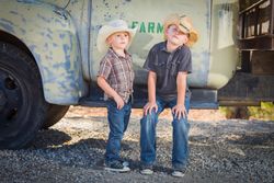 Young Boys Wearing Cowboy Hats Leaning Against an Antique Truck