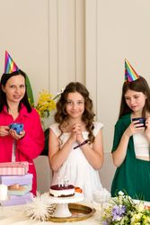Birthday girl in white dress, surrounded by family