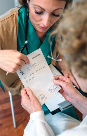 Doctor giving prescription to patient