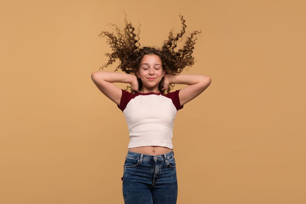 Girl with hair flying upwards, eyes closed, expressing calmness