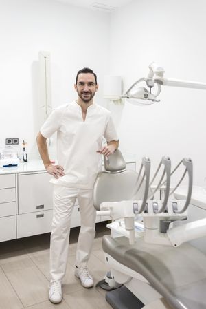Portrait of a handsome dentist wearing a uniform at work