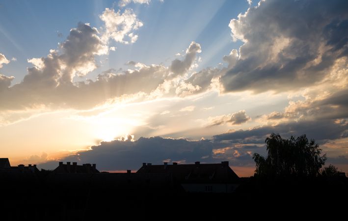 Sun coming through the clouds over rooftops