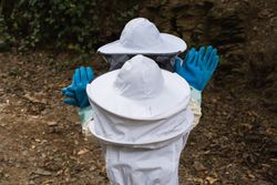 Faceless group of children in protective uniform in apiary