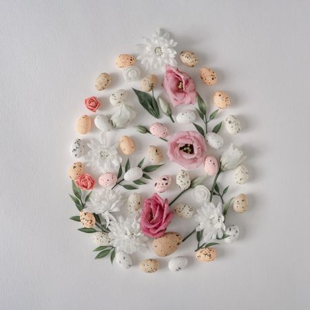 Creative flat lay composition with spring flowers in egg shape and gray background