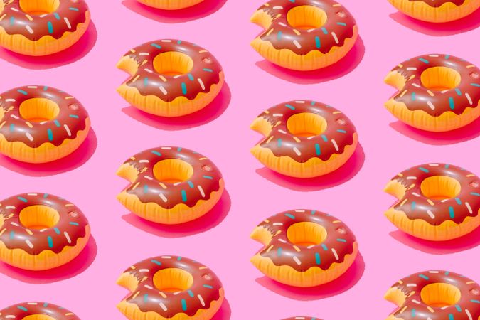 Inflatable doughnut pool toy pattern on pink background