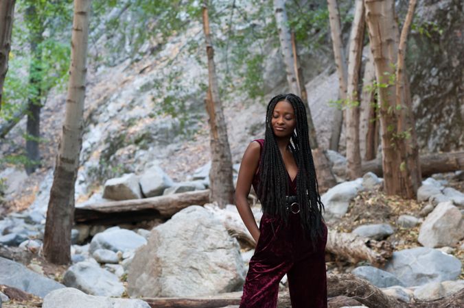 Black woman with eyes closed standing by a river