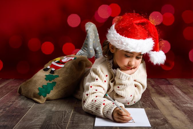 Child concentrating on writing a letter to Santa at Christmas time