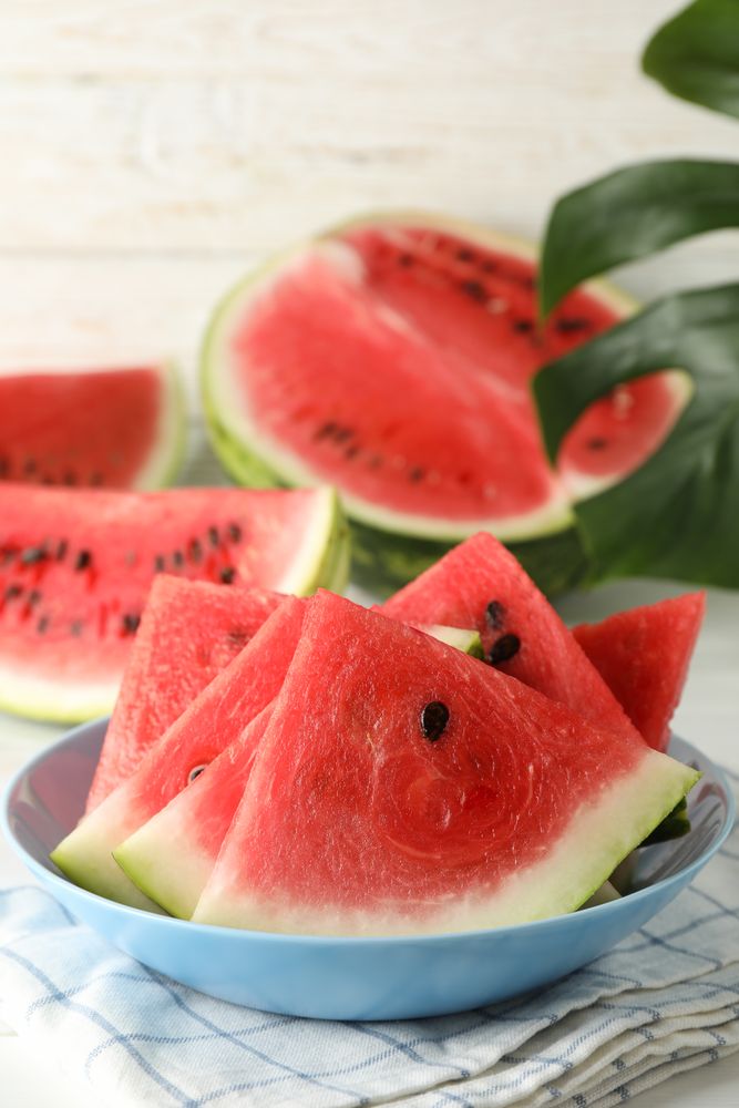 Composition with plate of fresh watermelon on blank wooden background