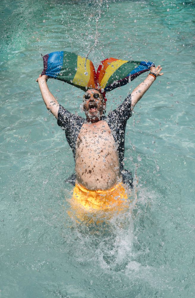 Excited gay man in swimming pool