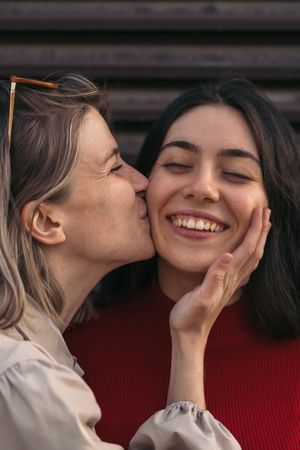 friends kissing on the cheek. Close-up. Blonde and brunette