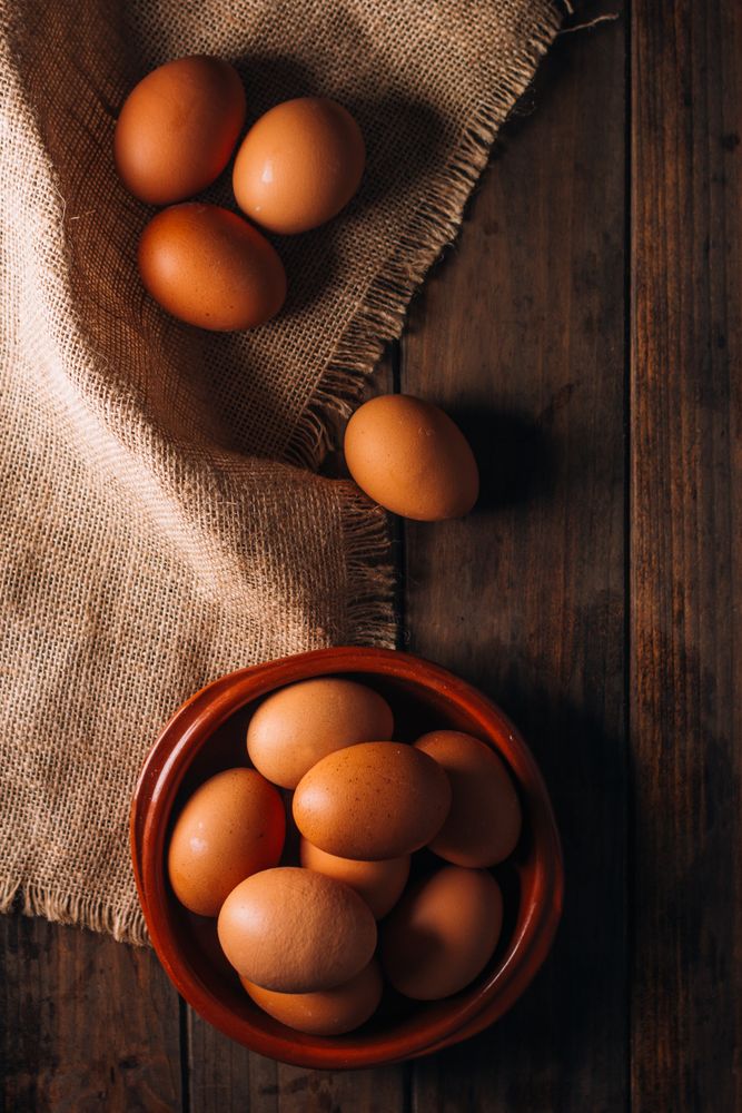 Chicken eggs on napkin on wooden table