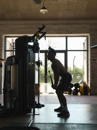 Black guy using exercise machine in gym