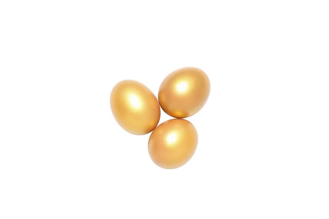 Concept of wealth and retirement - golden eggs, isolated on light background