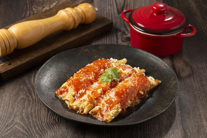 Pancakes stuffed with minced meat and topped with tomato sauce and grated cheese.