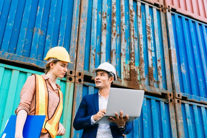 Asian male foreman with laptop with female colleague