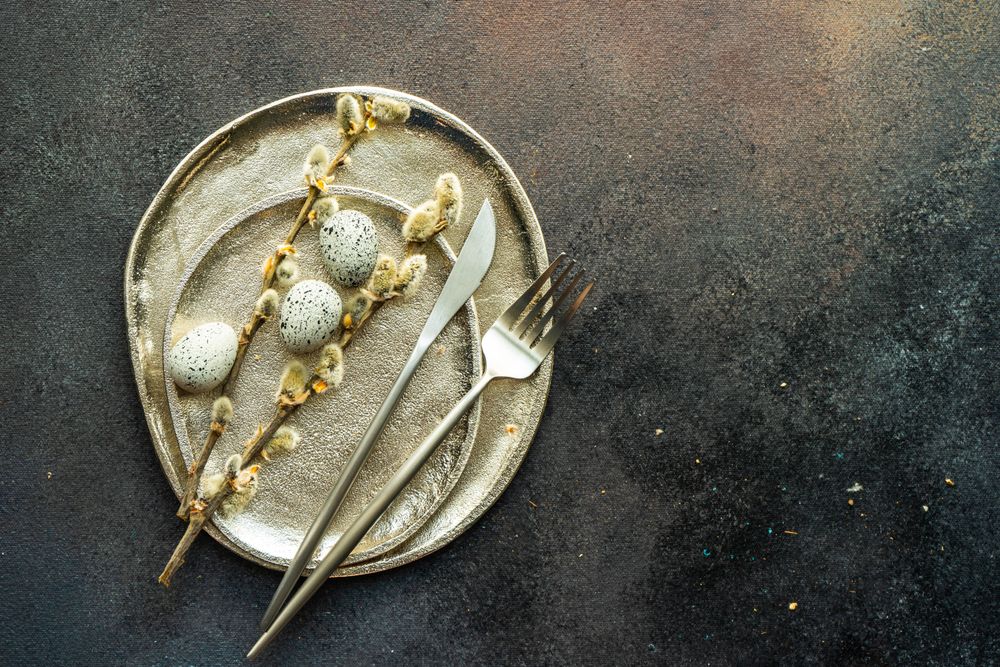 Easter table setting with eggs and pussy willow on neutral ceramic plates