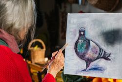 Anonymous woman painting on canvas in garden