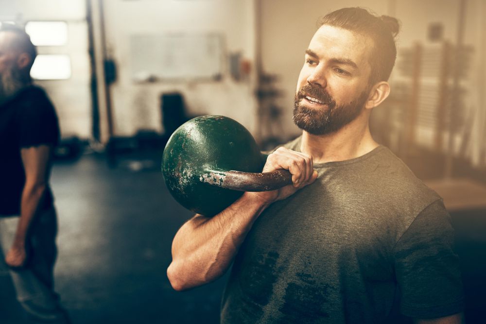 Man holding kettlebell to chest in class