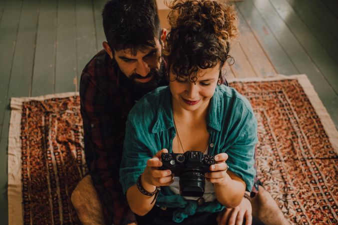 Young couple using photo camera at home