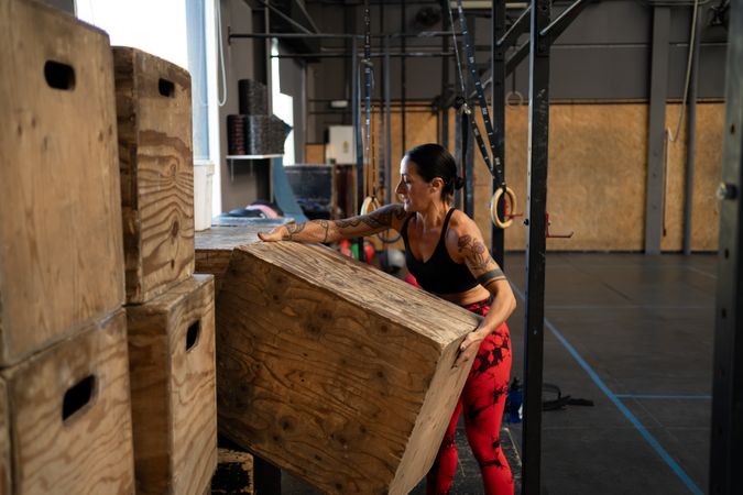 Woman organizing equipment alone in a cross training gym