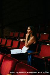 Female director observing a scene from red theater rows 41aXD4