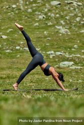 Woman doing three-legged downward dog yoga pose bGROe4