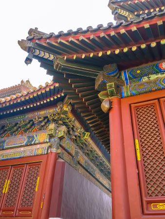 Close-up of ornate Chinese temple with intricate details, vibrant red and gold accents, and traditional wooden lattice doors