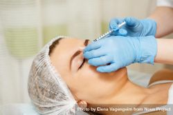 Cosmetologist at med spa injecting botox in female client 41qRO4