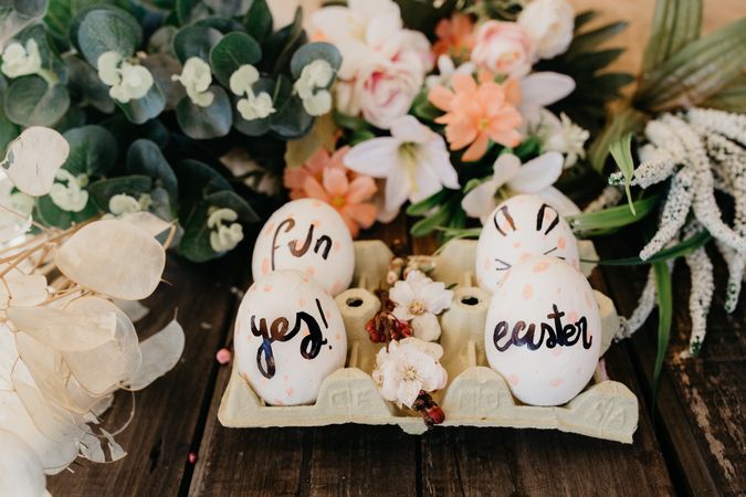 Easter eggs in container between decorative plants