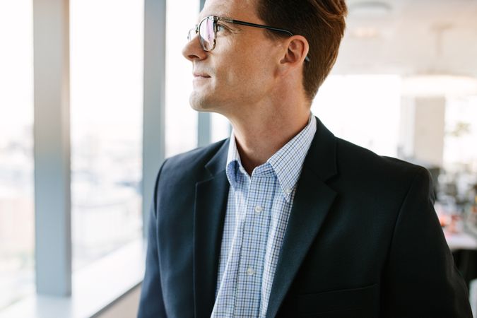 Thoughtful businessman standing in office