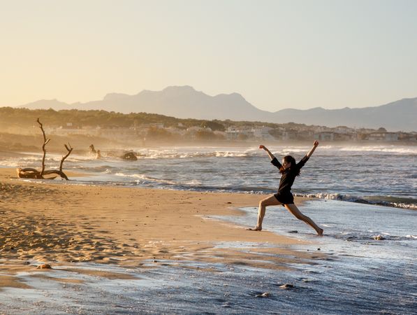 Woman with dancing near water on shore