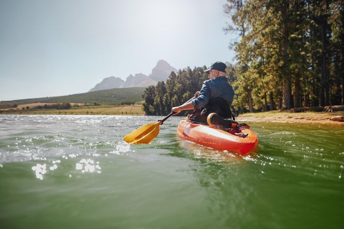 Rear view of a mature man canoeing in a lake