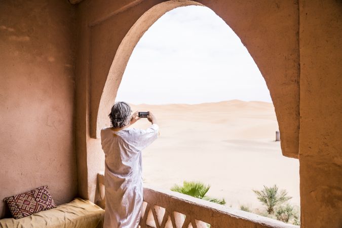 Man taking photo of desert from balcony