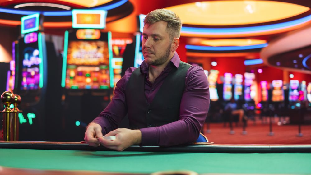 White Male Poker Dealer Is Dealing Playing Cards In Luxurious Casino.